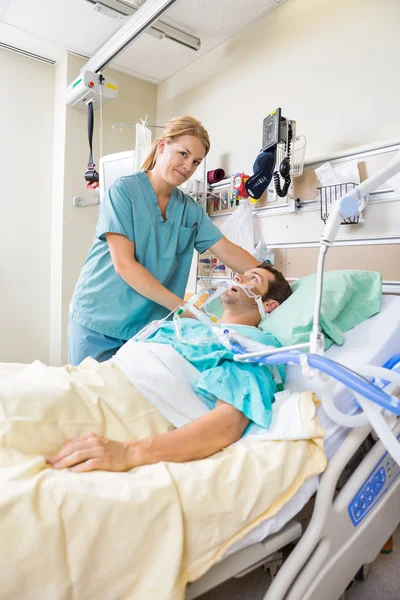 Enfermeira ajustando o travesseiro do paciente no hospital — Fotografia de Stock