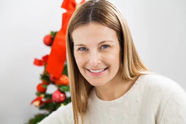 微笑对圣诞树的女人 — 图库照片