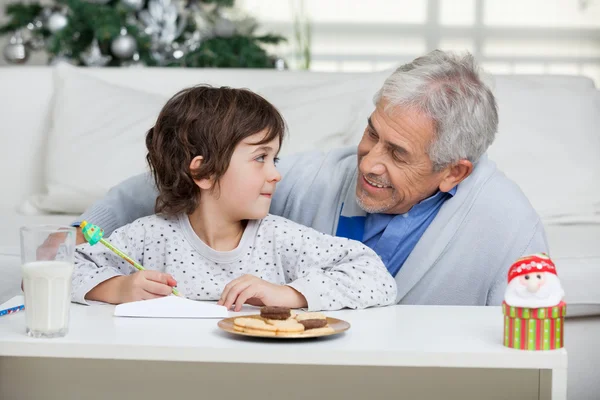 Pojke och farfar skriva brev till jultomten — Stockfoto