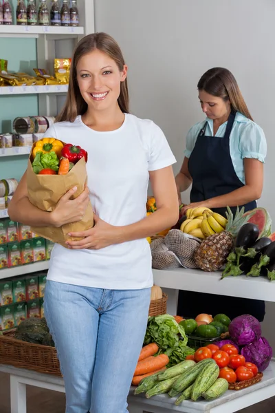 Mujer sosteniendo bolsa de comestibles en supermercado — Foto de Stock