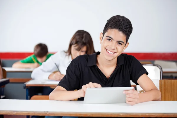 Estudante universitário masculino usando tablet digital na mesa — Fotografia de Stock