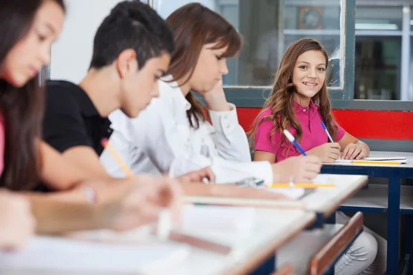 Teenage skolflicka sitter vid skrivbord — Stockfoto