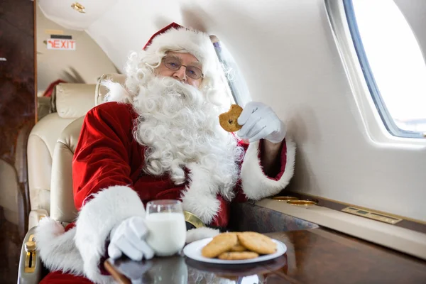 Santa met cookies en melk in prive-jet — Stockfoto