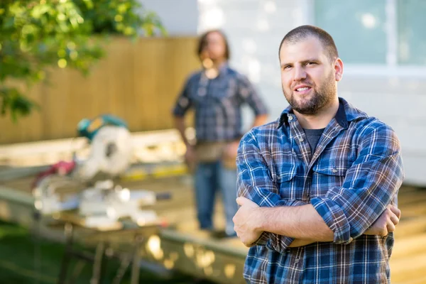 Trabajador manual seguro con las manos dobladas en el sitio de construcción — Foto de Stock