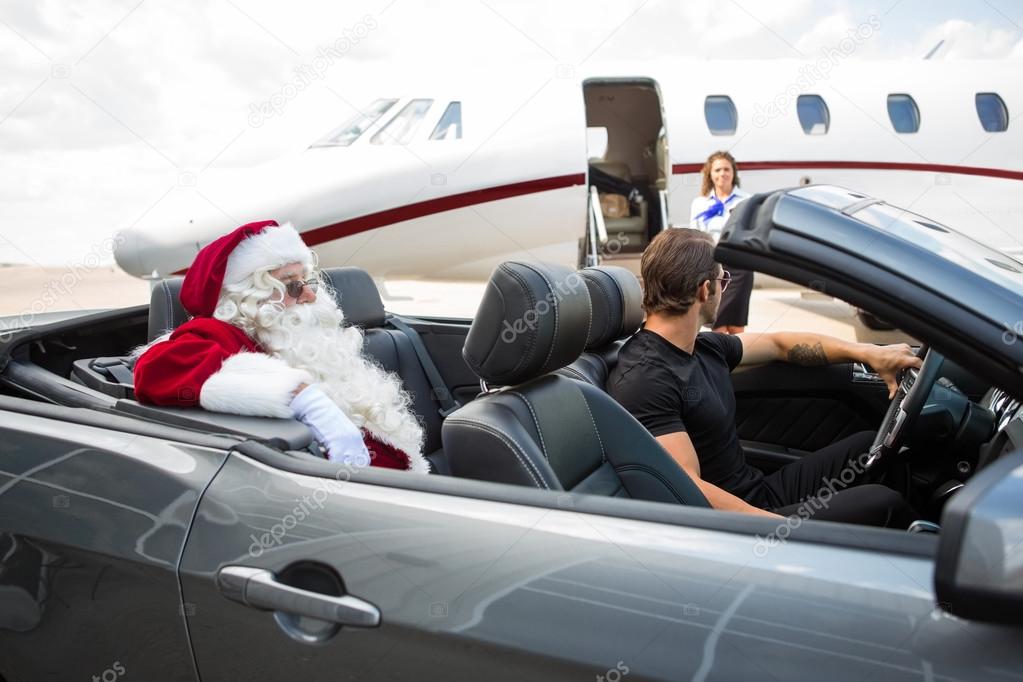 Santa And Chauffeur In Convertible While Airhostess Against Priv
