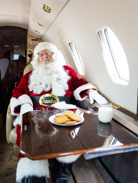 Santa con los ojos cerrados relajante en jet privado —  Fotos de Stock