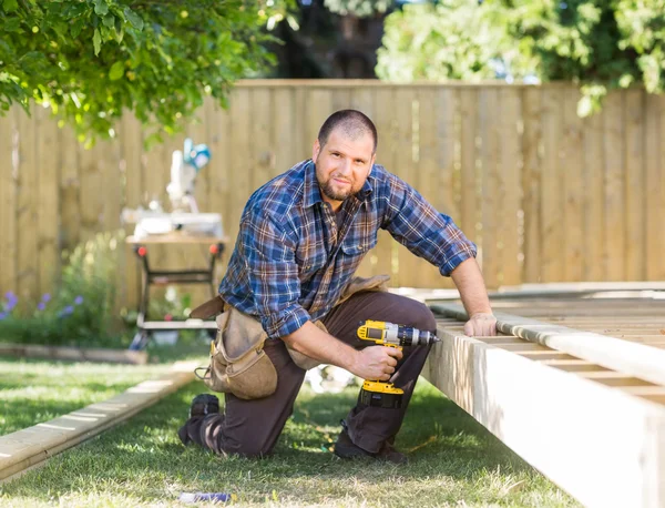 Dělník vrtání dřeva na staveništi — Stock fotografie