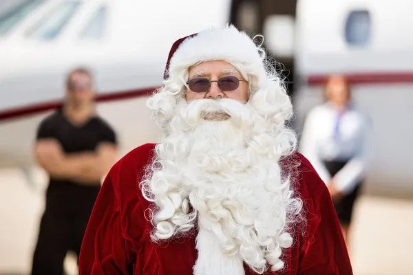 Santa em pé contra jato privado — Fotografia de Stock