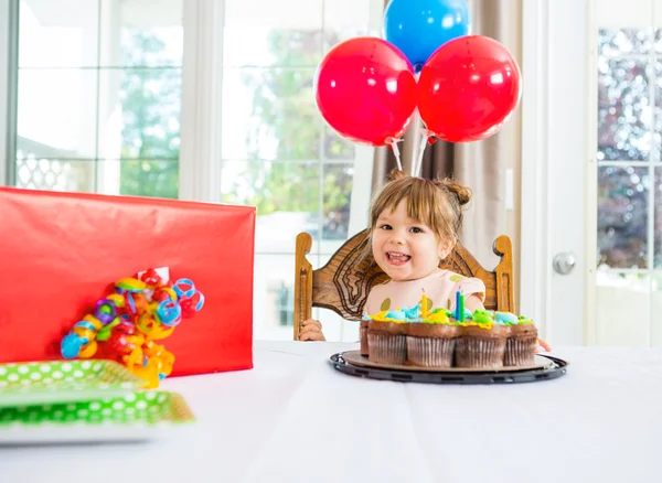 Menina de aniversário com bolo e presente na mesa — Fotografia de Stock