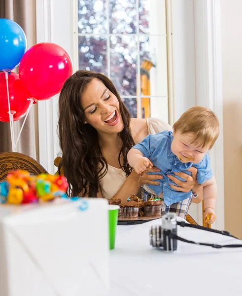 Madre sosteniendo niño con las manos sucias cubiertas con hielo pastel —  Fotos de Stock