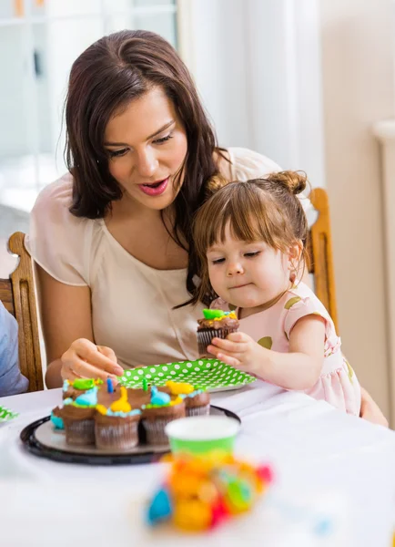 Madre con ragazza mangiare cupcake alla festa di compleanno — Foto Stock