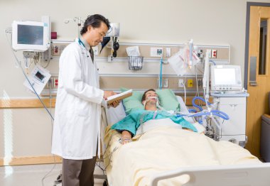 Doktor hastanın raporu inceleyerek pano ile