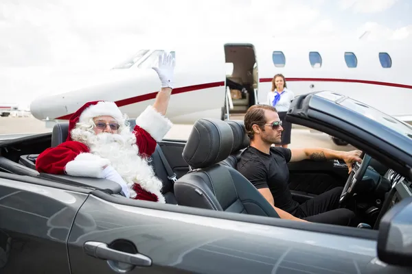 Santa Waving Hand While Driver Driving Convertible Against Priva — Stock Photo, Image