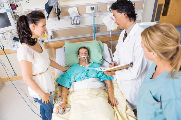 Mulher olhando para o médico examinando paciente — Fotografia de Stock