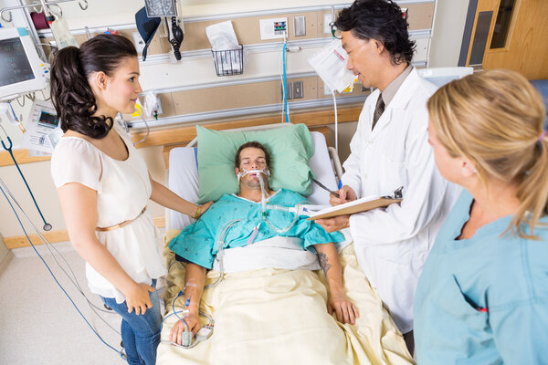 Woman Looking At Doctor Examining Patient