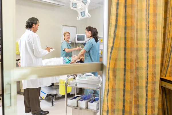 Врач и медсестры лечат пациента — стоковое фото