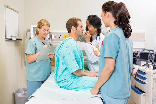 Equipe médica examinando paciente no hospital — Fotografia de Stock