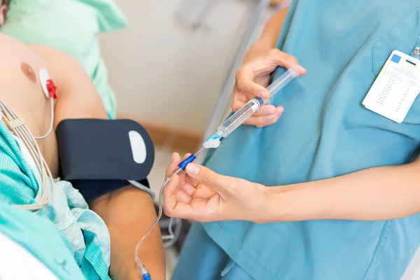 Nurse Injecting Dosage In IV Tube Attached To Patient — Stock Photo, Image