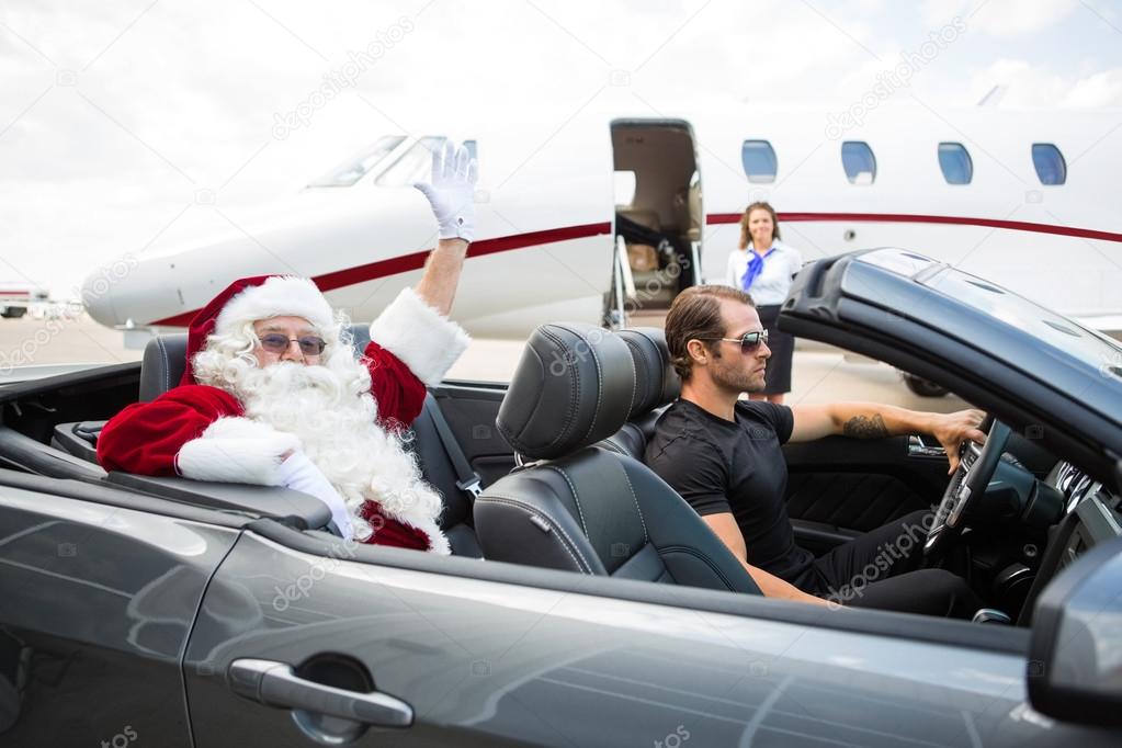 Santa Waving Hand While Driver Driving Convertible Against Priva