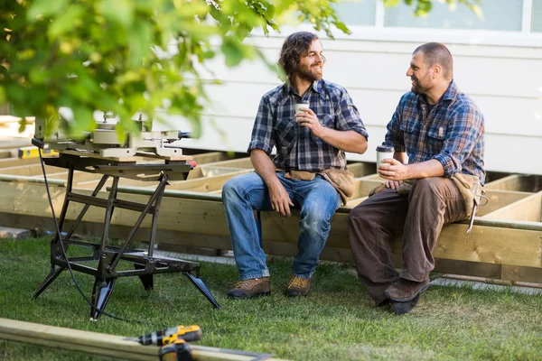 Carpenters With Disposable Cups Looking At Each Other On Frame — Stock Photo, Image