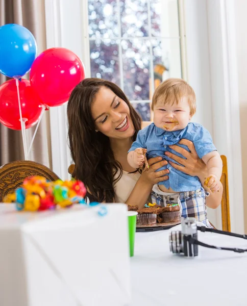 Moeder bedrijf jongen met rommelig handen bedekt met Cake slagroom — Stockfoto