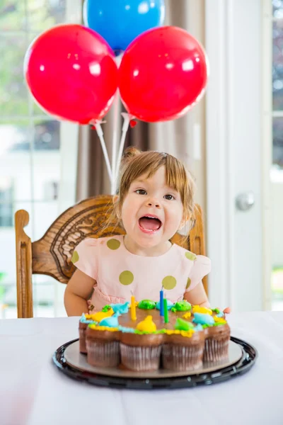 Ragazza con la bocca aperta seduta davanti alla torta — Foto Stock