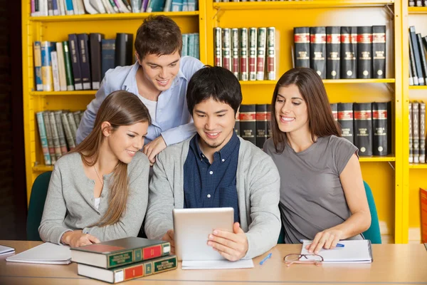 デジタルで学生は大学図書館を支えるで一緒に勉強してタブレットします。 — ストック写真