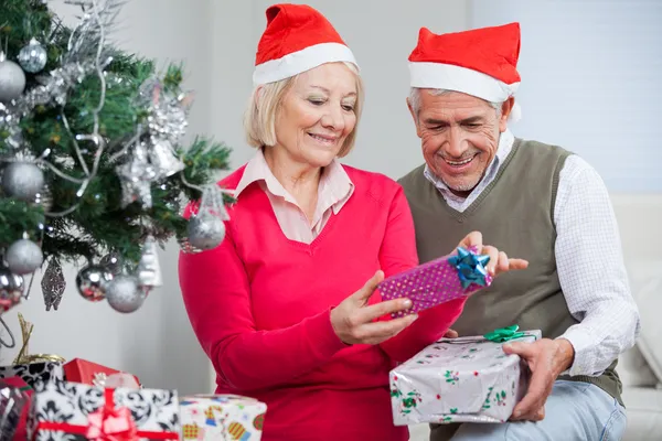 Para starszy patrząc na Boże Narodzenie prezenty — Zdjęcie stockowe