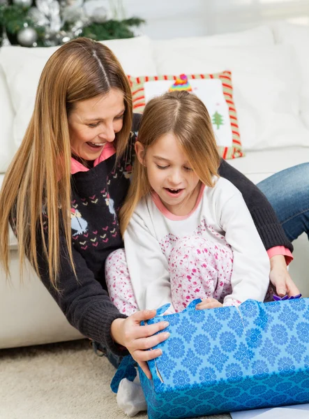 Moeder en meisje openen kerstcadeau — Stockfoto