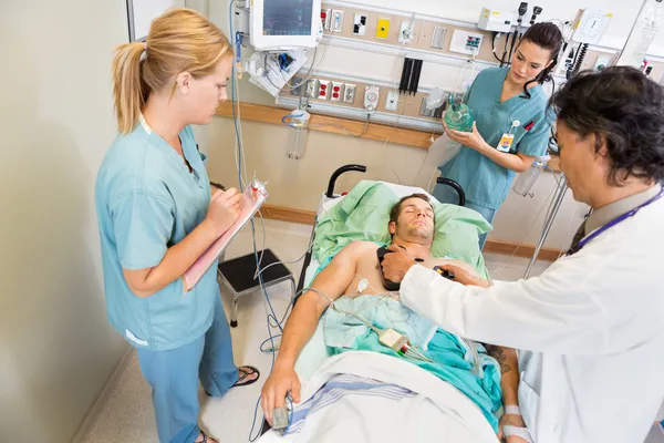 Doctor desfibrilando al paciente crítico en el hospital — Foto de Stock