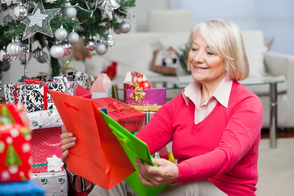 Lächelnde Seniorin wählt Taschen — Stockfoto