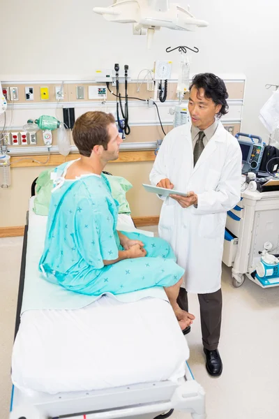 Doctor discutiendo informe sobre tableta digital con paciente — Foto de Stock