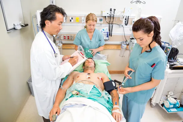 Médecin et infirmières traitant un patient critique — Photo
