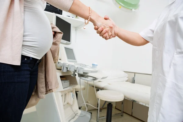 Embarazada mujer y doctor sacudiendo manos — Foto de Stock