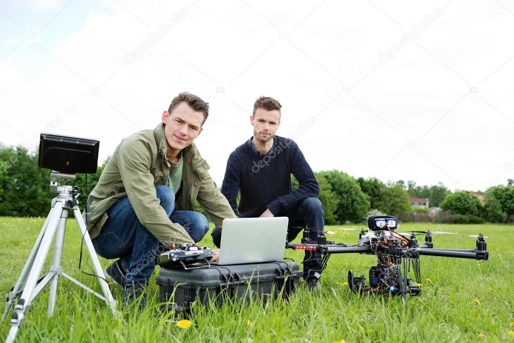 Engineers Using Laptop By UAV Helicopter