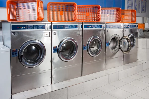 Machines à laver et paniers vides dans une rangée — Photo