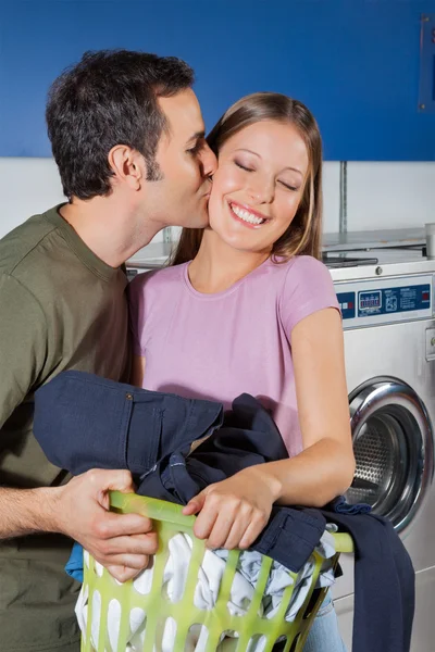Hombre besándose mujer en mejilla en lavandería —  Fotos de Stock