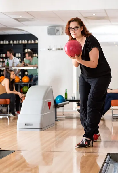 Jovem mulher jogando no bowling beco no clube — Fotografia de Stock