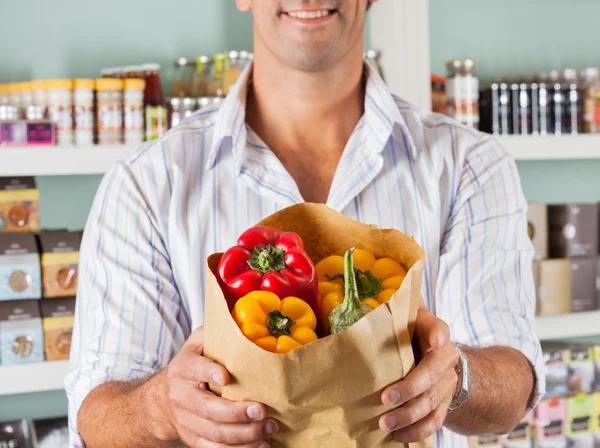 Male Customer Showing Bellpeppers In Paper Bag