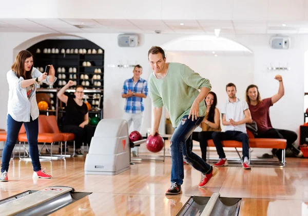 Man bowlen met vrienden juichende club — Stockfoto