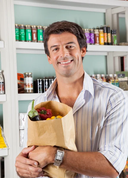 Man met plantaardige tas in supermarkt — Stockfoto