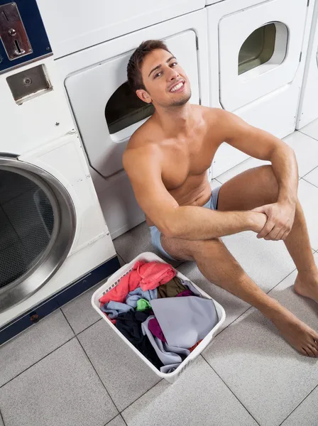 Άνθρωπος με πλυντήριο καλάθι περιμένοντας να πλύνει τα ρούχα — Φωτογραφία Αρχείου