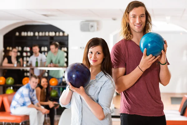 Hombre y mujer sosteniendo bolas de bolos en el club — Foto de Stock