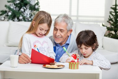 Noel Baba'ya mektup yazarken yardım çocuklar dedesi