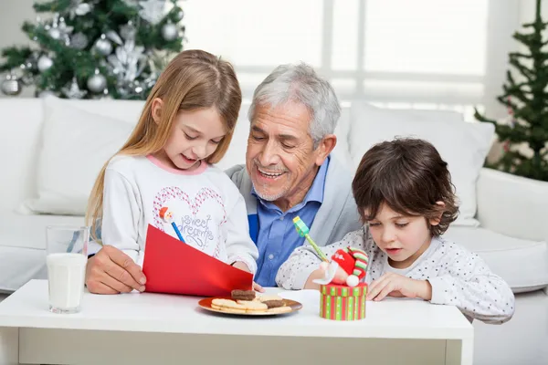 Avô ajudando as crianças a escrever cartas para o Papai Noel — Fotografia de Stock