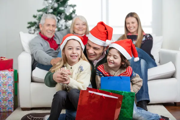 Niños y padre con regalos durante la Navidad — Foto de Stock