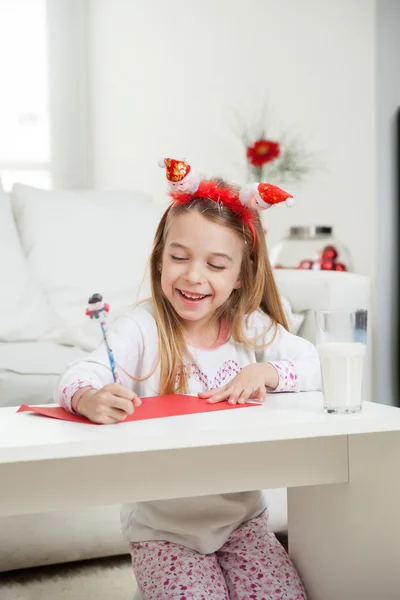Menina feliz escrevendo carta para Papai Noel — Fotografia de Stock