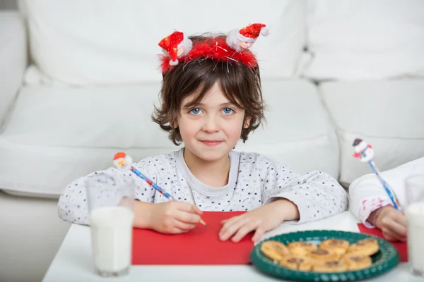 Jongen dragen santa hoofdband schrijven brief thuis — Stockfoto