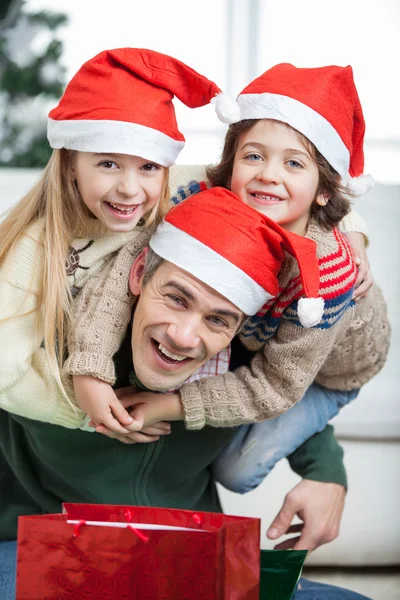 Speelse vader meeliften kinderen tijdens Kerstmis — Stockfoto
