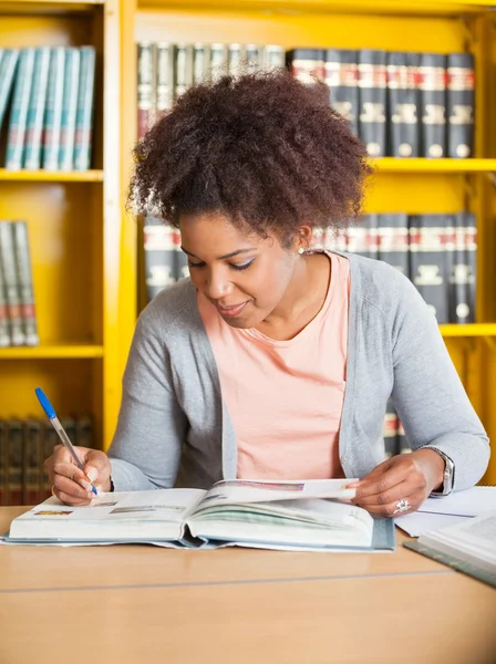 Student Writing In Book At Library — Stock Photo, Image